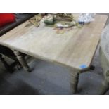 An Edwardian pine dining table standing on four fluted legs