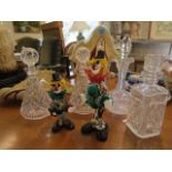 A selection of glassware to include cut glass decanters and a claret jug, two glass clowns, and an