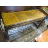 A Burr oak desk with a central drawer, H framed stretcher below on square legs with brass rail,