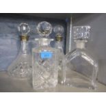 Four glass decanters to include a pair with silver collars, an Orrefors example and another