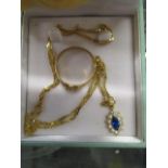 A 14ct gold necklace and pendant set with a marquise shaped blue stone, surrounded by white stones