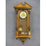 A Victorian walnut cased Vienna wall clock of architectural design and having an enamel dial with