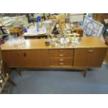 A retro G-Plan teak sideboard with twin cupboard doors, four drawers and further storage door, on