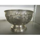 An Edwardian silver footed bowl with scrolled leaf and floral repousse decoration, cartouche with