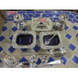 A silver plated condiment set with blue glass liners and a small selection of silver and silver