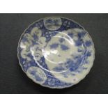 A 19th century Japanese blue and white charger with wavy rim edge, with an offset reserve of a