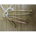 Three 9ct gold brooches/tie pins, one fashioned as a torpedo