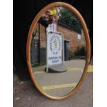 An oval wall hanging mirror having gilt highlights