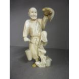 A late 19th/early 20th century carved ivory figure of an elderly gent holding a turtle