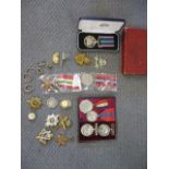 A selection of cap badges, WWI and WWII campaign medals, other medals and items