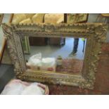 A modern gilded rococo style wall mirror, 38" x 50"