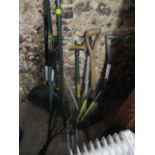 A selection of garden tools to include a spade, a rake and others