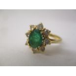 A gold coloured metal ring set with an emerald, surrounded by eight diamonds, stamped 750, size J/K,