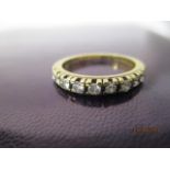 A gold coloured metal half eternity ring set with nine diamonds, stamped 18ct, size L, 2.6g