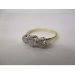 An 18ct gold and platinum coloured three stone diamond ring, the central stone approximately 0.