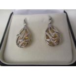 A pair of 18ct yellow and white gold earrings of drop design, with pierced decoration, set with