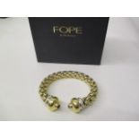 A Fope Flexit 18ct yellow and white gold bracelet, the finials each set with a sapphire cabochon and