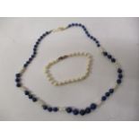 A Lapis Lazuli and pearl necklace on a yellow metal clasp and a pearl bracelet on a gold coloured