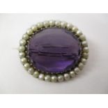 A Victorian gold coloured metal brooch set with an amethyst, approximately 25mm x 20mm within a