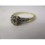 A gold and platinum coloured ring set with an oval diamond, approximately 0.65ct with four
