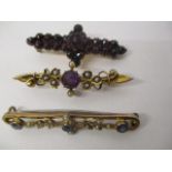 Three yellow metal stick style brooches, two set with amethysts and pearls and the other garnets,