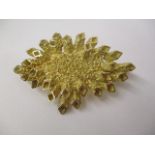 A gold coloured metal irregular shaped brooch with diamond shaped motifs, stamped JAD, 17g