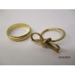 Two 18ct gold rings comprising a wedding band and the other fashioned as a bow, 9.4g, total