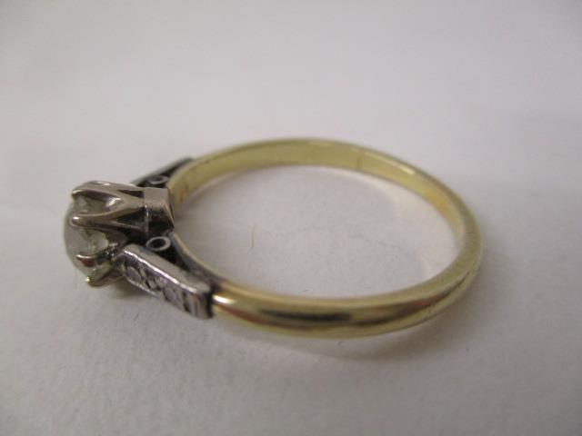 A gold and platinum coloured ring set with an oval diamond, approximately 0.65ct with four - Image 3 of 5