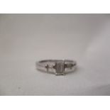 An 18ct white gold ring set with a baguette cut diamond, each shoulder set with a pair of baguette