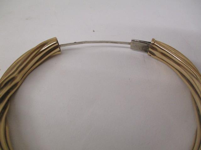 A gold coloured metal bangle with rope twist style ornament, stamped 9kt, 22.2g total - Image 3 of 3