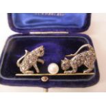 A gold and white coloured metal brooch fashioned as two kittens playing with a pearl, set with