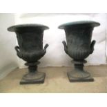 A pair of Victorian green painted, cast iron campana garden urns, with twin mask handles and