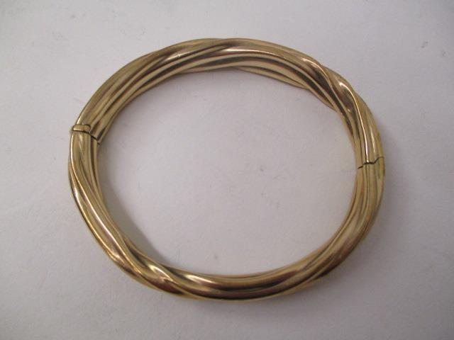 A gold coloured metal bangle with rope twist style ornament, stamped 9kt, 22.2g total - Image 2 of 3