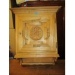 A reconstituted pine hanging cabinet with a carved door, 27"h, 21"w