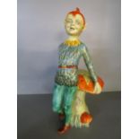 A rare Art Deco English pottery figurine of a Pixie standing in front of a toadstool in oranges,