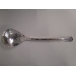 An Edwardian Arts & Crafts silver jam spoon with oval and dot decoration, flattened trefoil finial