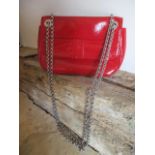 A Lulu Guinness red patent leather cross over bag with chain shoulder strap