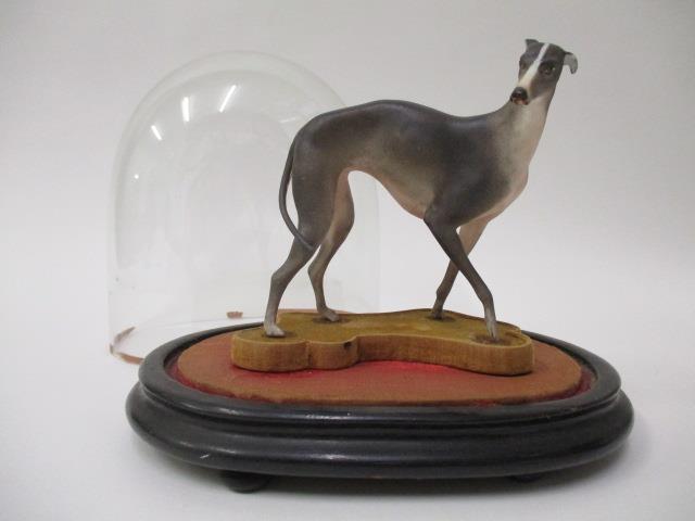 A 19th century continental porcelain model of a greyhound in grey and white, 4 1/2" h, on a shaped