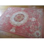 An Italian Society Aubusson rug with a coral pink background and floral detail, 67" x 91"