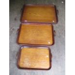 Three early 20th century oak, twin handled trays, graduating in size