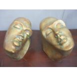 A pair of contemporary bookends in the form of painted pottery heads