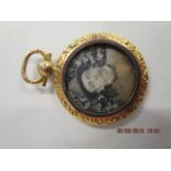 A late Victorian/Edwardian yellow metal pendant, with photographs to the front and reverse, on a