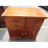 A modern pine side cabinet having four short drawers and two cupboard doors below, 33" h x 33 1/2"w