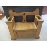 A Harrison & Gibbson oak hall bench with a pierced splat back and hinged seat