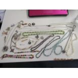 A quantity of silver and costume jewellery to include a garnet beaded necklace