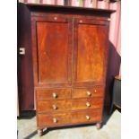 An early 19th century mahogany linen press having twin cupboard doors above two short and two long