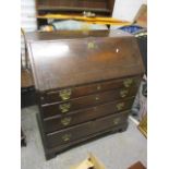 A George II mahogany oak bureau, the fall flap enclosing central cupboards flanked by pigeonholes,