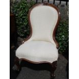 A Victorian walnut spoonback salon chair with cream upholstery and carved cabriole legs