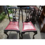 A pair of 1920s Chippendale style mahogany chairs, having a pierced splat back and ball and claw