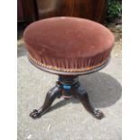 A Victorian mahogany swivel topped piano stool, standing on three scrolled feet